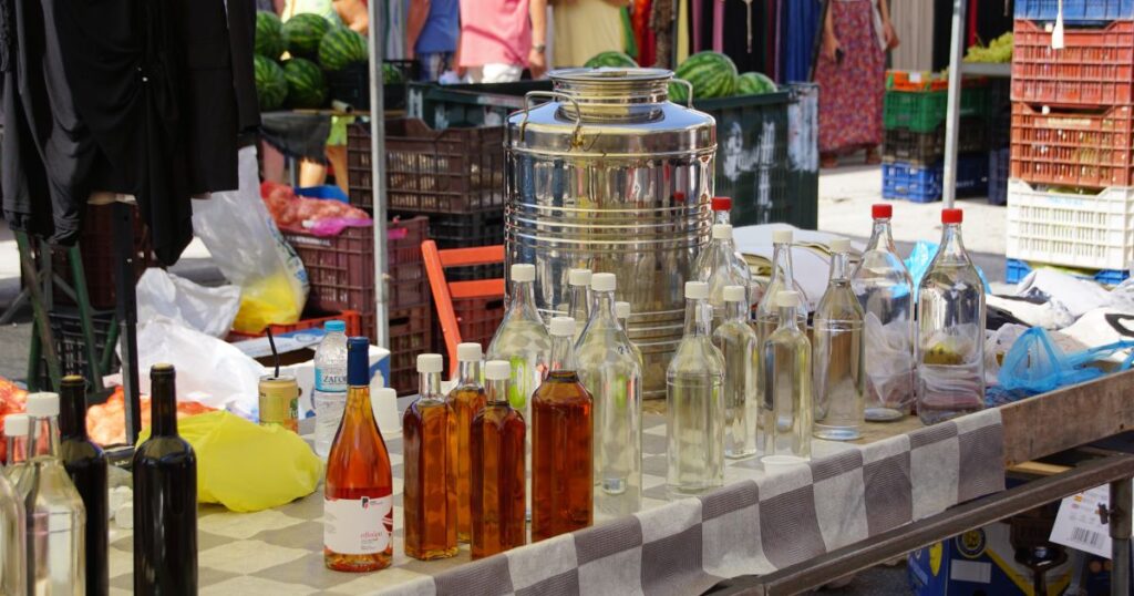 Marktkraam in Griekenland met traditionele producten zoals olijfolie, sterke drank, watermeloen